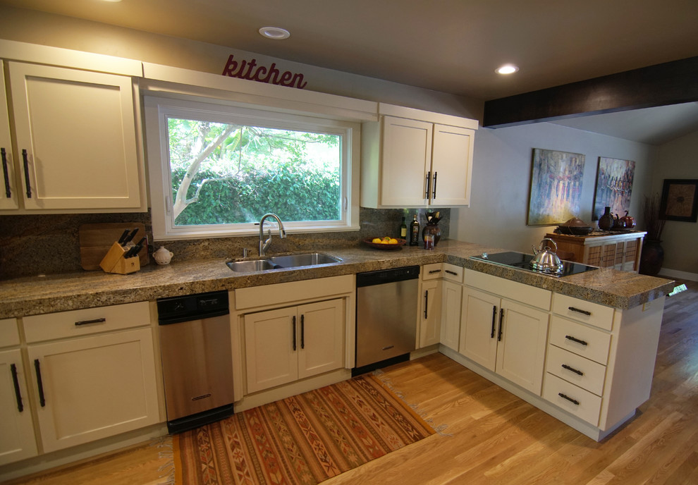 Photo of a mid-sized transitional u-shaped eat-in kitchen in Sacramento with a double-bowl sink, shaker cabinets, white cabinets, granite benchtops, beige splashback, stone slab splashback, stainless steel appliances, light hardwood floors, a peninsula, beige floor and beige benchtop.