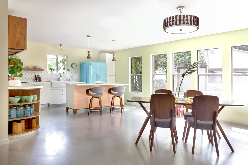 Стильный дизайн: кухня-столовая в стиле ретро с желтыми стенами, бетонным полом и серым полом - последний тренд