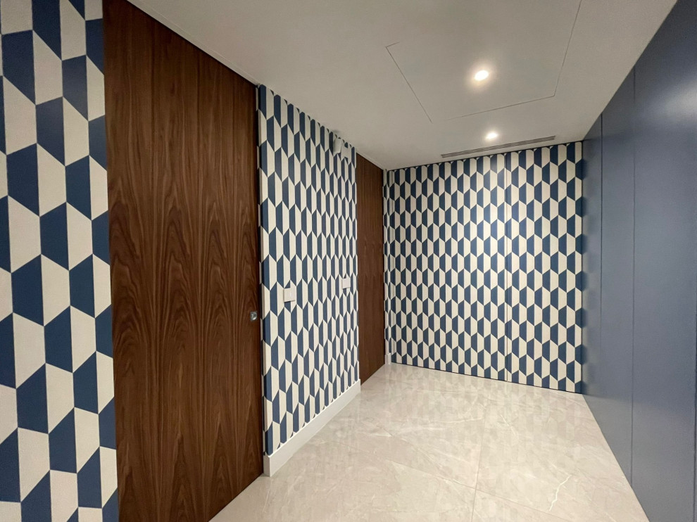 This is an example of a small contemporary foyer in Milan with laminate floors, a double front door, a blue front door, grey floor and wallpaper.