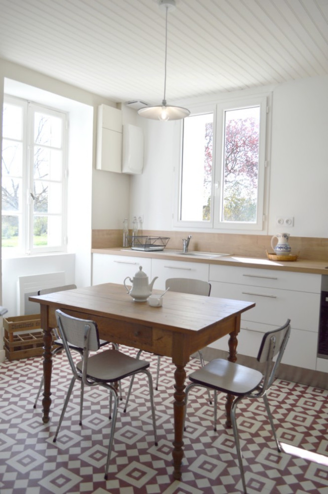 Идея дизайна: кухня-гостиная среднего размера в стиле ретро с белыми фасадами, деревянной столешницей, светлым паркетным полом и полуостровом