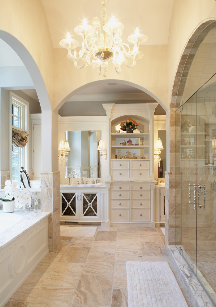 Photo of a traditional bathroom in Minneapolis with white cabinets, an alcove shower, beige tile and limestone.