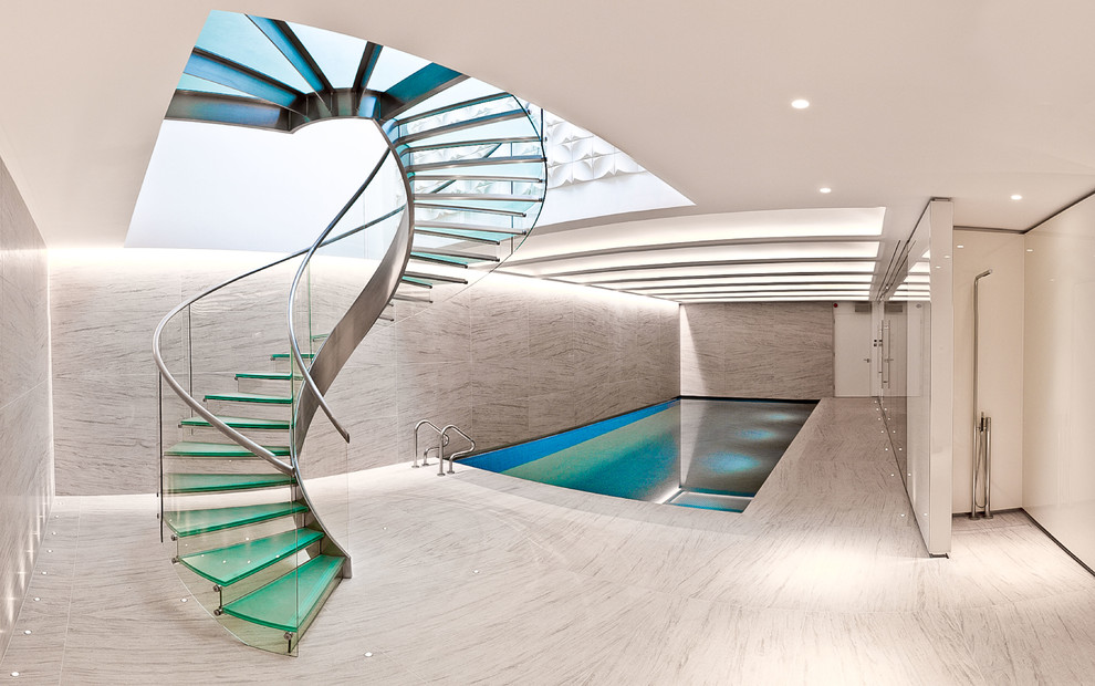 Inspiration for a contemporary glass curved staircase in London with glass risers and glass railing.