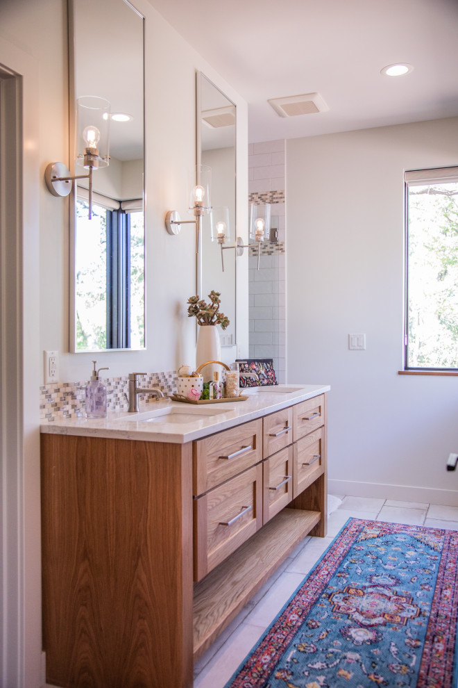 Inspiration for a mid-sized transitional kids' white tile and porcelain tile porcelain tile and white floor alcove shower remodel with shaker cabinets, medium tone wood cabinets, a two-piece toilet, white walls, an undermount sink, quartzite countertops, a hinged shower door and white countertops