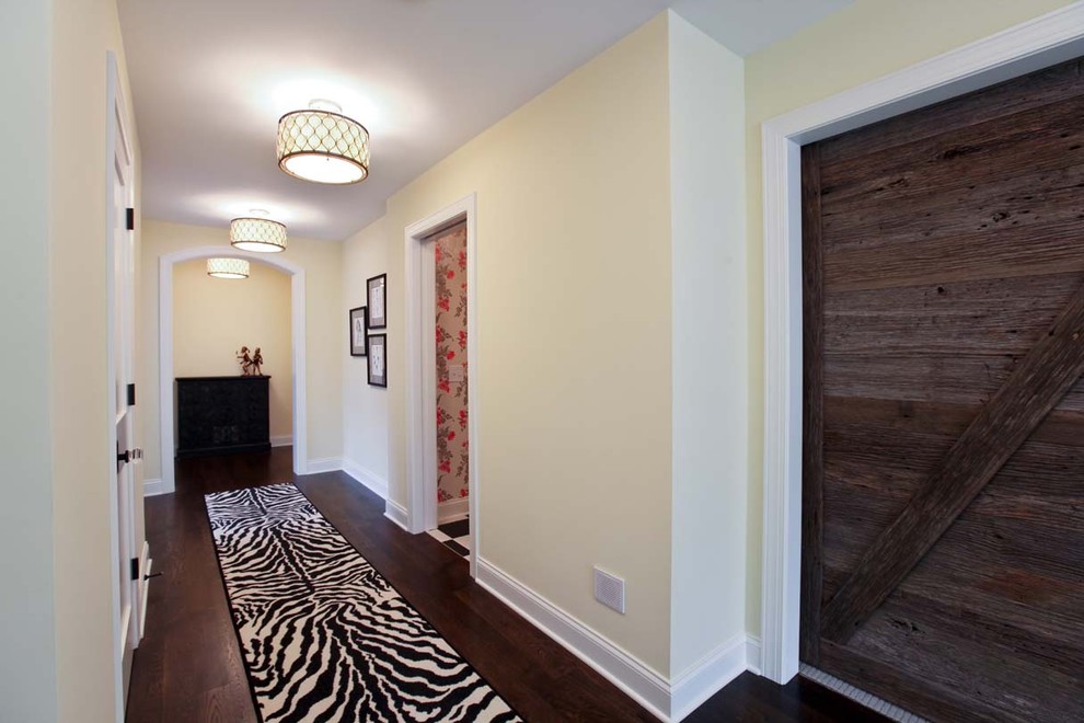 Photo of a traditional hallway in Minneapolis with beige walls, dark hardwood floors and brown floor.