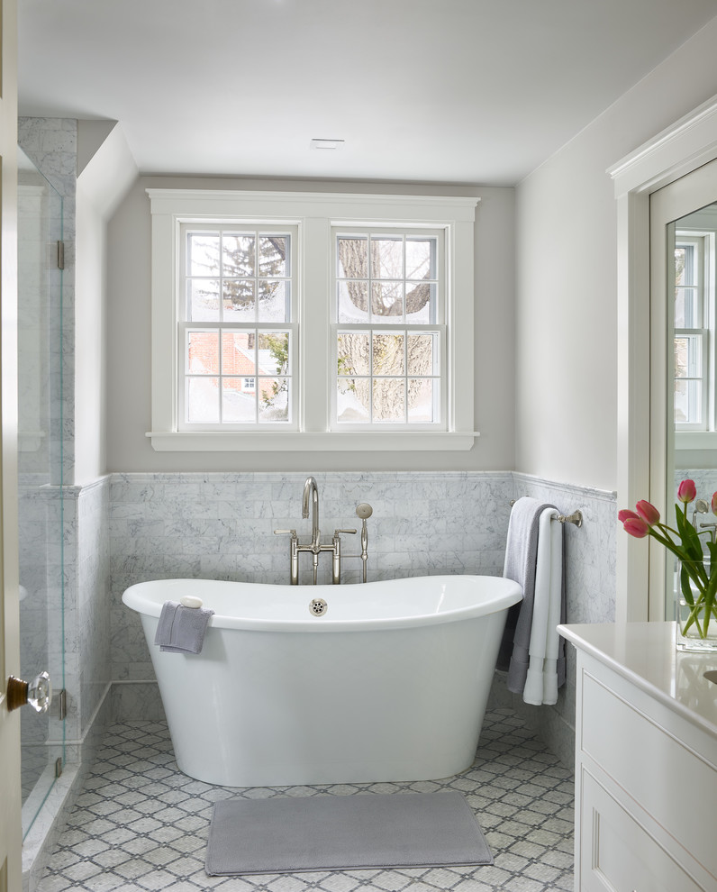 Traditional bathroom in Boston with beaded inset cabinets, white cabinets, a freestanding tub, gray tile, marble, grey walls, mosaic tile floors, grey floor and white benchtops.