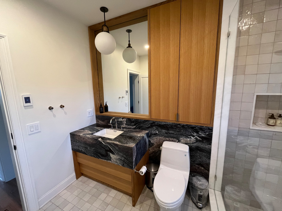 Exemple d'une grande salle de bain moderne en bois brun avec un placard à porte plane, une douche ouverte, WC à poser, un carrelage beige, des carreaux en terre cuite, un mur blanc, tomettes au sol, un lavabo encastré, un plan de toilette en granite, un sol beige, une cabine de douche à porte battante, un plan de toilette noir, une niche, meuble simple vasque et meuble-lavabo encastré.