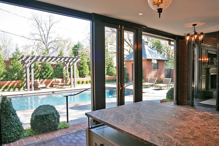 Example of a mid-sized transitional l-shaped brick floor open concept kitchen design in Charlotte with an undermount sink, shaker cabinets, white cabinets, marble countertops, beige backsplash, subway tile backsplash, stainless steel appliances and an island