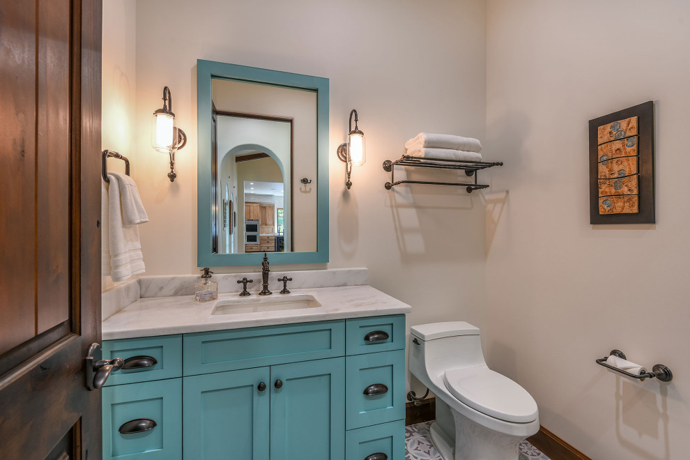 This is an example of a small mediterranean bathroom in Orlando with shaker cabinets, turquoise cabinets, a curbless shower, a one-piece toilet, white walls, porcelain floors, an undermount sink, quartzite benchtops, multi-coloured floor, a hinged shower door, white benchtops, a single vanity and a built-in vanity.
