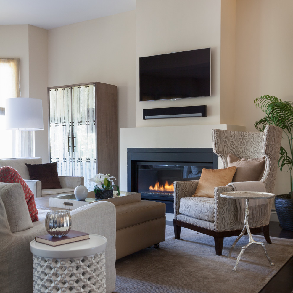 Photo of a large contemporary living room in San Francisco with dark hardwood floors, a standard fireplace, a wall-mounted tv, beige walls, a plaster fireplace surround and brown floor.