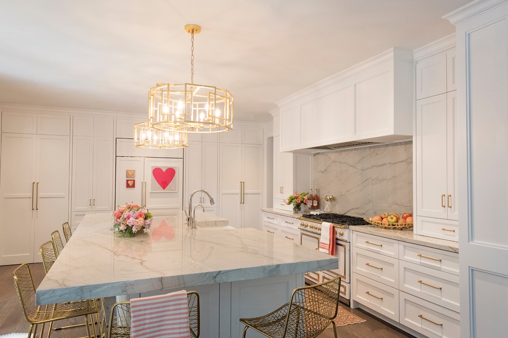 Large transitional l-shaped medium tone wood floor and brown floor open concept kitchen photo with a farmhouse sink, recessed-panel cabinets, white cabinets, quartzite countertops, white backsplash, stone slab backsplash, paneled appliances and an island
