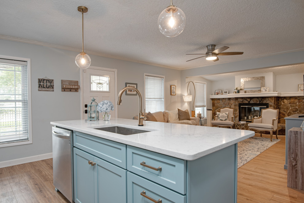 Mid-sized contemporary l-shaped eat-in kitchen in Tampa with an undermount sink, shaker cabinets, turquoise cabinets, quartz benchtops, white splashback, marble splashback, stainless steel appliances, vinyl floors, with island, beige floor and white benchtop.