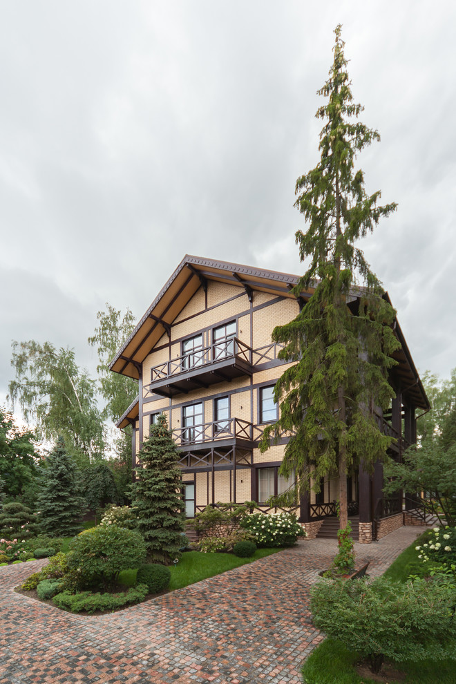 Photo of a country three-storey white exterior in Moscow with wood siding and a gable roof.
