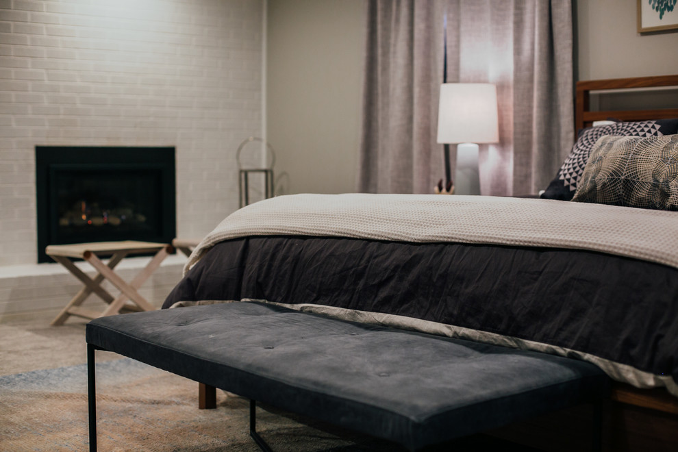 Photo of an expansive transitional master bedroom in Denver with grey walls, carpet, a standard fireplace, a brick fireplace surround and grey floor.