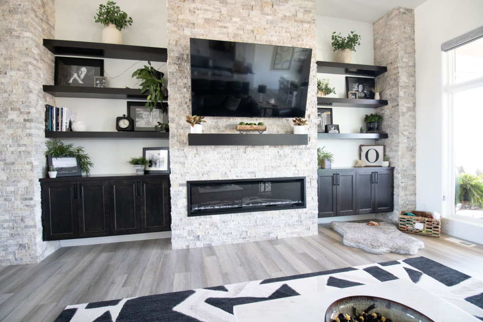 This is an example of a modern open concept living room in Omaha with white walls, a ribbon fireplace, a wall-mounted tv and wood.