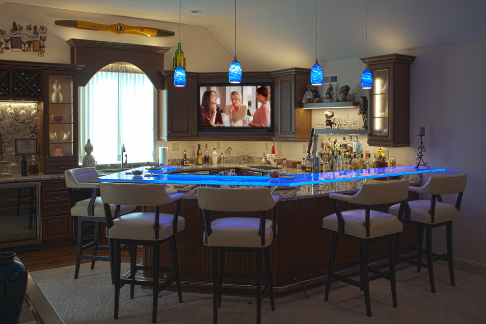 Design ideas for a large transitional l-shaped seated home bar in Huntington with an undermount sink, glass-front cabinets, dark wood cabinets, glass benchtops, medium hardwood floors, brown floor and blue benchtop.