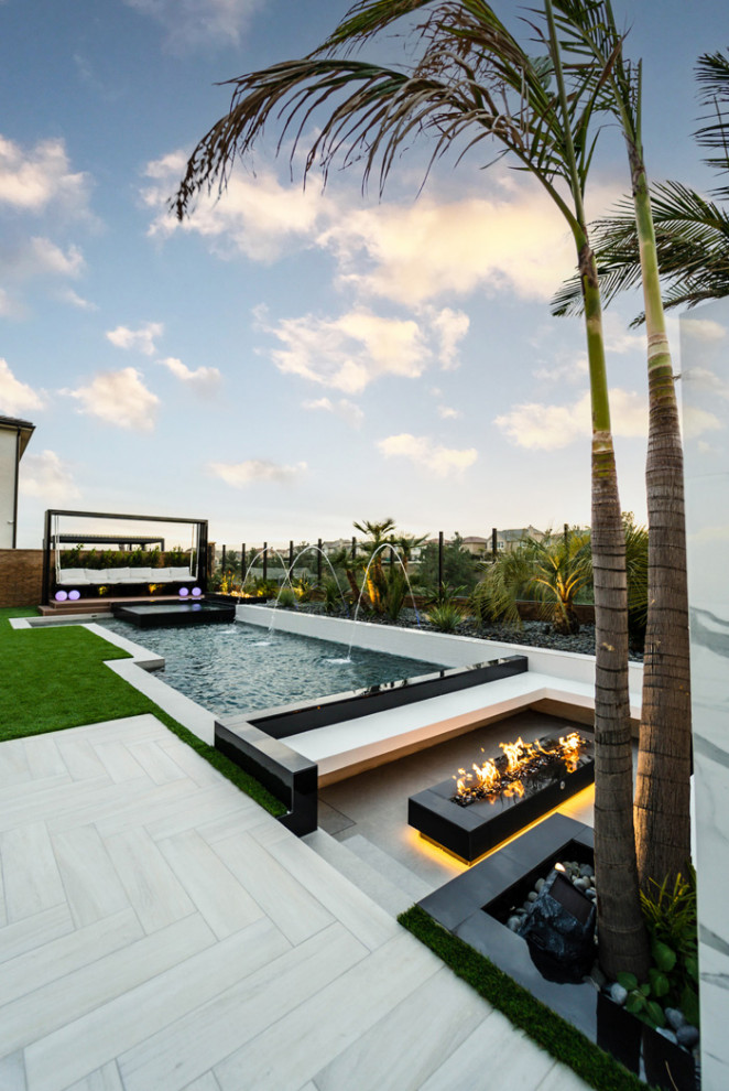 Diseño de piscina minimalista de tamaño medio en forma de L en patio trasero con suelo de baldosas