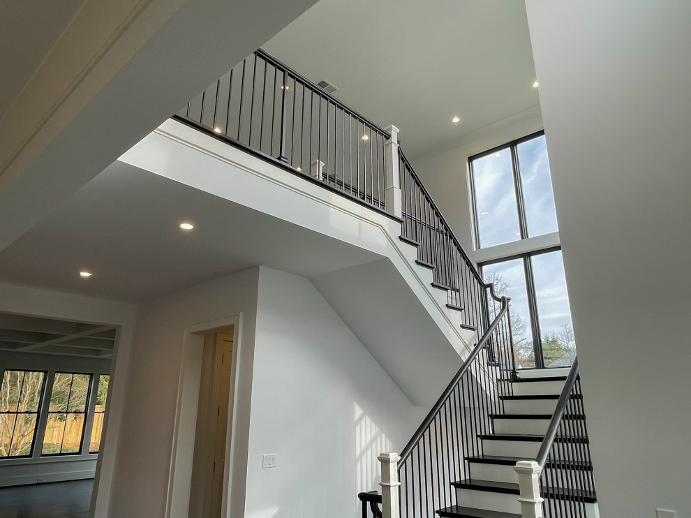 This is an example of a large classic wood floating mixed railing staircase in DC Metro with wood risers and panelled walls.