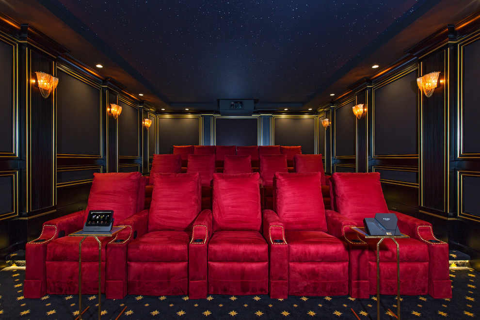 This is an example of a large traditional enclosed home theatre in Los Angeles with black walls, carpet and a projector screen.