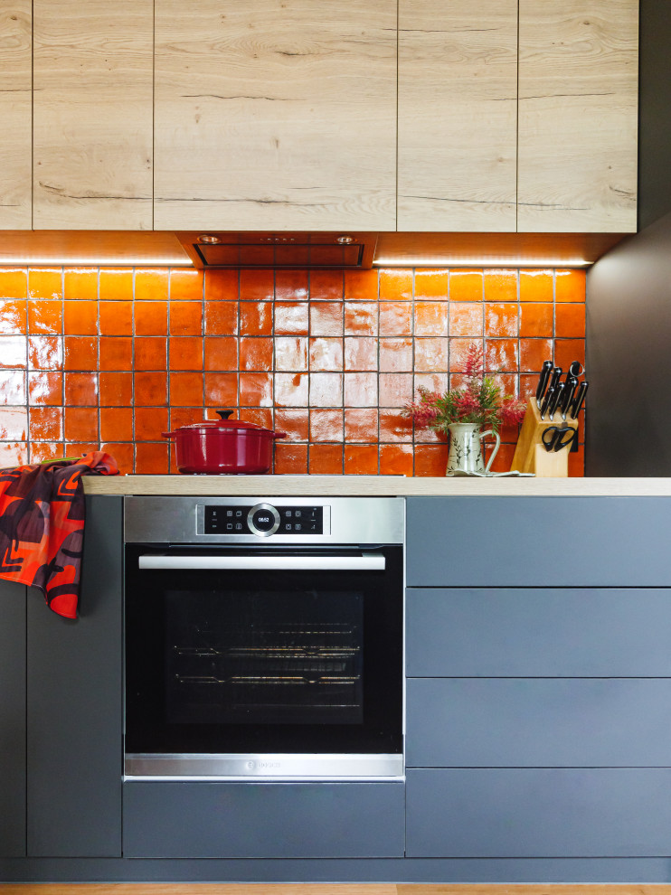 Design ideas for a contemporary u-shaped eat-in kitchen in Melbourne with a double-bowl sink, flat-panel cabinets, laminate benchtops, orange splashback, ceramic splashback, black appliances, medium hardwood floors, a peninsula and exposed beam.
