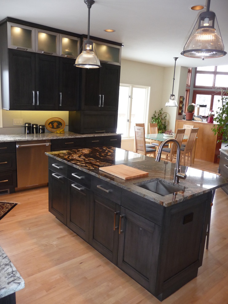 Large transitional u-shaped eat-in kitchen in Milwaukee with an undermount sink, flat-panel cabinets, grey cabinets, granite benchtops, white splashback, porcelain splashback, stainless steel appliances, light hardwood floors and with island.