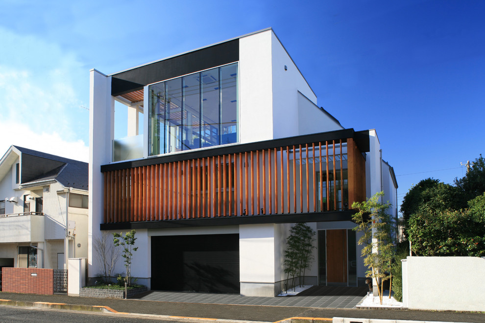 Design ideas for a large modern two-storey white exterior in Tokyo with wood siding and a shed roof.