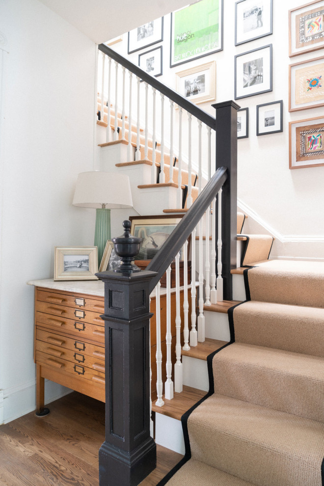 This is an example of a transitional carpeted l-shaped staircase in Jacksonville with carpet risers and wood railing.