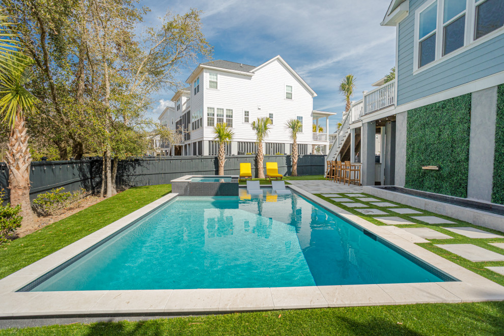 This is an example of a mid-sized contemporary backyard pool in Charleston with concrete pavers.