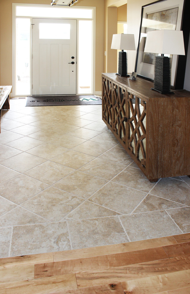Example of a large transitional ceramic tile front door design in Cedar Rapids with beige walls and a white front door