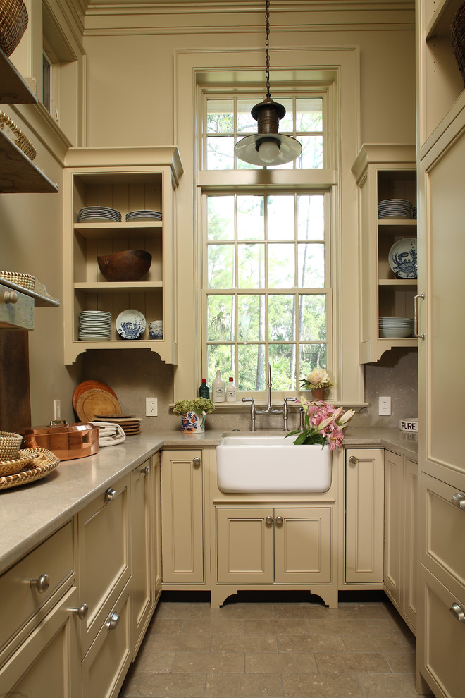 Photo of a traditional u-shaped kitchen in Charleston with a farmhouse sink, beaded inset cabinets, beige cabinets and panelled appliances.