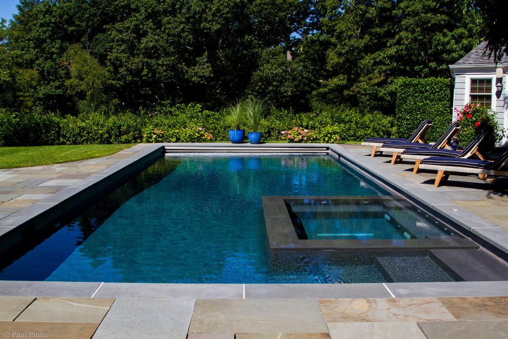 Example of a large transitional backyard stone and rectangular lap hot tub design in New York