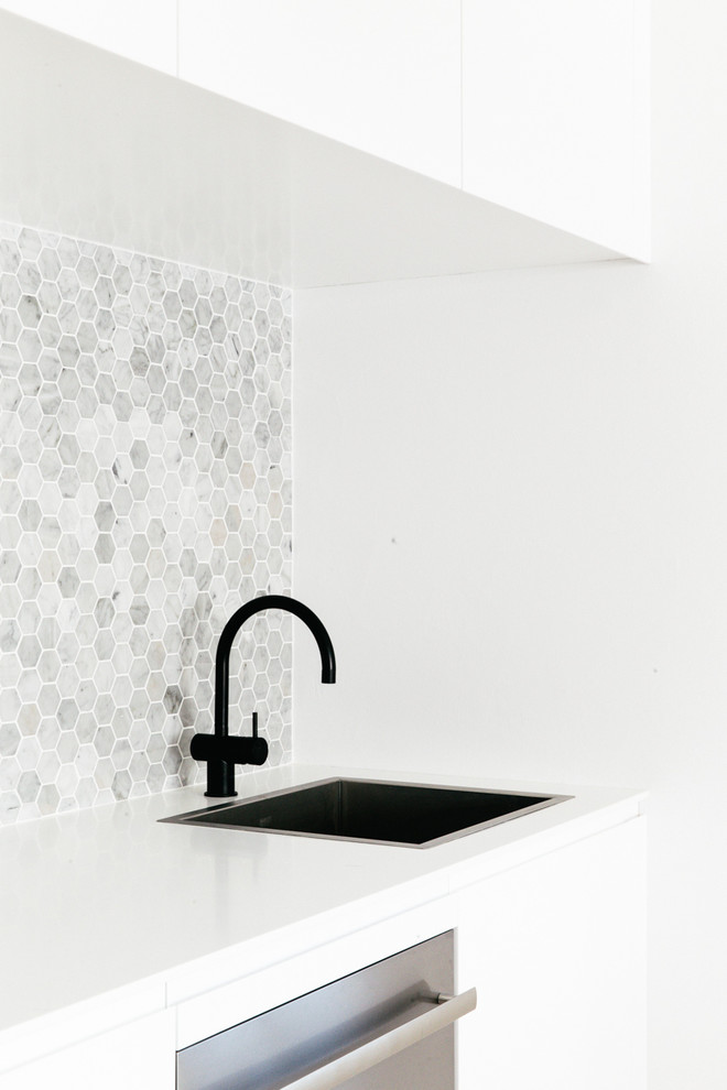 Scandinavian single-wall eat-in kitchen in Sydney with grey splashback, stone tile splashback and black appliances.