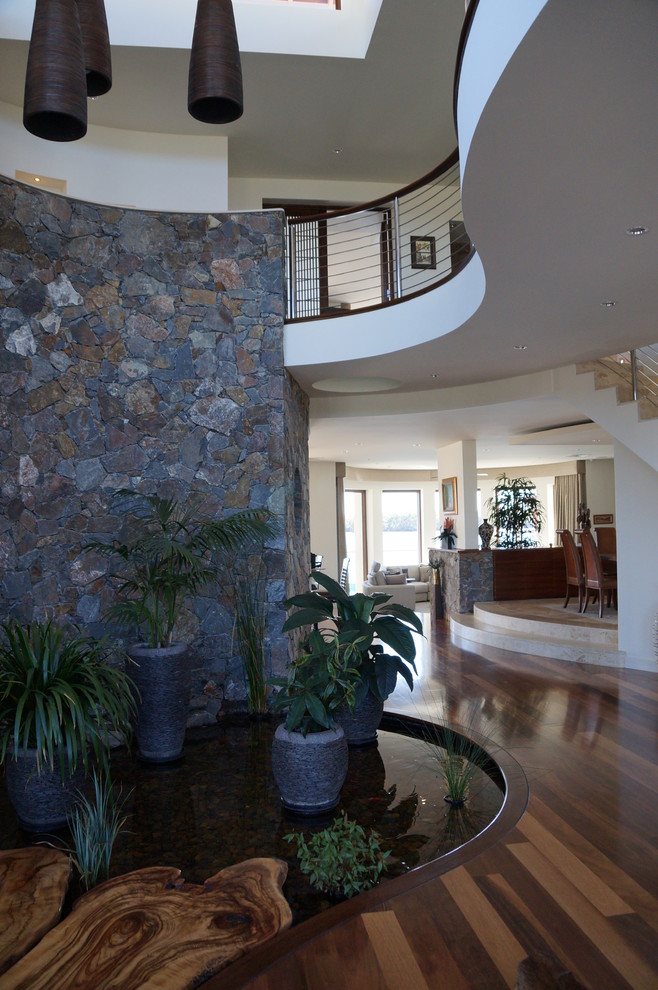 This is an example of a tropical entryway in Gold Coast - Tweed with medium hardwood floors.