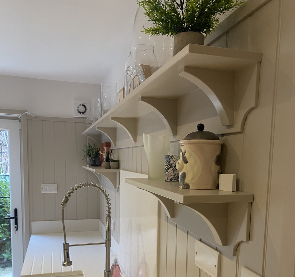 This is an example of a medium sized traditional galley utility room in Sussex with a belfast sink, shaker cabinets, beige cabinets, white splashback, tonge and groove splashback, lino flooring, brown floors and white worktops.