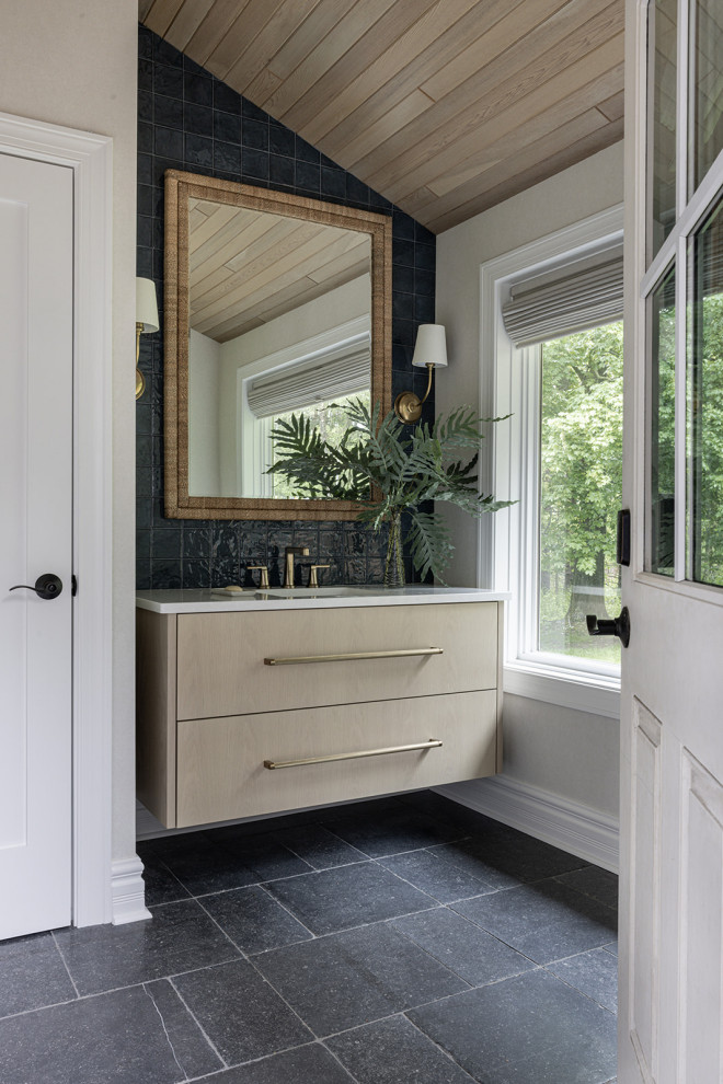 Beach style black tile black floor, vaulted ceiling and wood ceiling powder room photo in Chicago with flat-panel cabinets, light wood cabinets, beige walls, an undermount sink, white countertops and a floating vanity