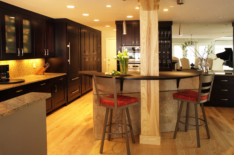Photo of a contemporary open plan kitchen in Denver with panelled appliances, shaker cabinets and dark wood cabinets.
