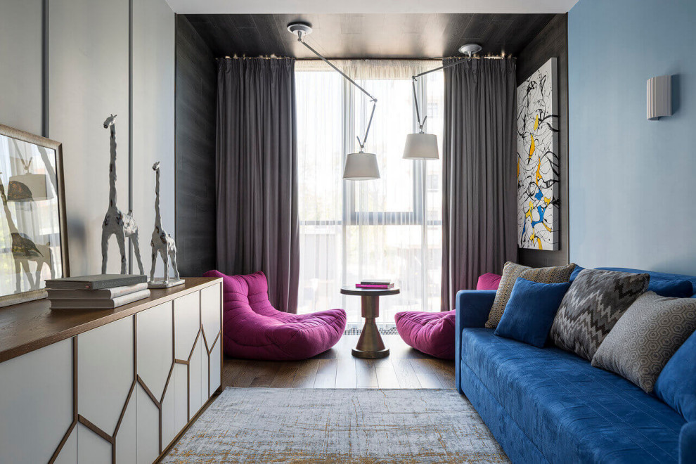 На фото: парадная гостиная комната среднего размера в морском стиле с разноцветными стенами, зоной отдыха, синим диваном, темным паркетным полом и коричневым полом