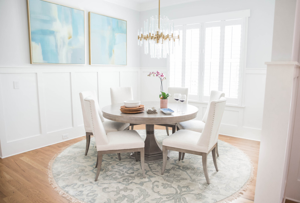 Esempio di una sala da pranzo classica con pareti bianche, parquet chiaro, pavimento beige e boiserie