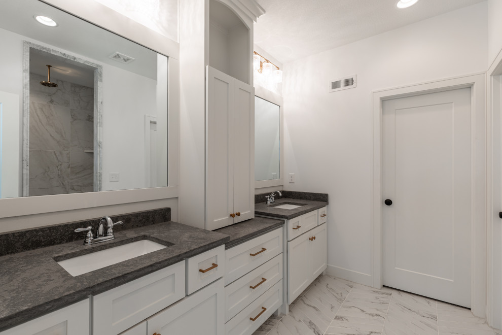 Example of a large minimalist master gray tile and stone tile porcelain tile, white floor, double-sink and vaulted ceiling bathroom design in Kansas City with shaker cabinets, white cabinets, white walls, an undermount sink, soapstone countertops, black countertops and a built-in vanity