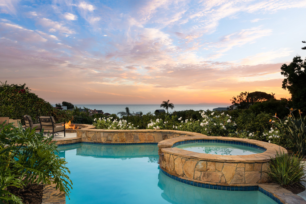 Inspiration for a mediterranean backyard custom-shaped pool in Orange County with a hot tub.