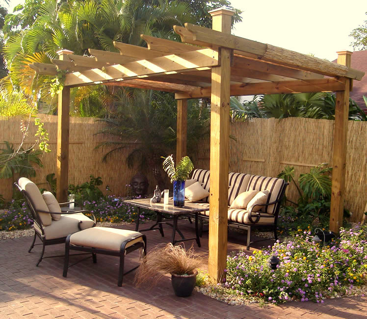 Small country backyard patio in Miami with a container garden, brick pavers and a pergola.