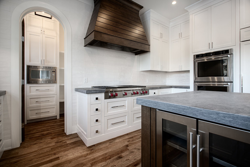 Example of a large transitional u-shaped eat-in kitchen design in Calgary with shaker cabinets, paneled appliances and an island