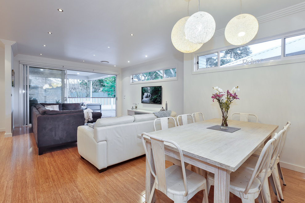 Mid-sized contemporary open plan dining in Sydney with white walls, bamboo floors and beige floor.
