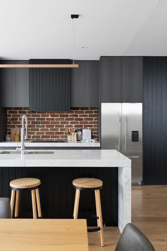 Inspiration for a contemporary galley eat-in kitchen in Sydney with an undermount sink, flat-panel cabinets, grey cabinets, red splashback, brick splashback, stainless steel appliances, medium hardwood floors, with island, brown floor and white benchtop.