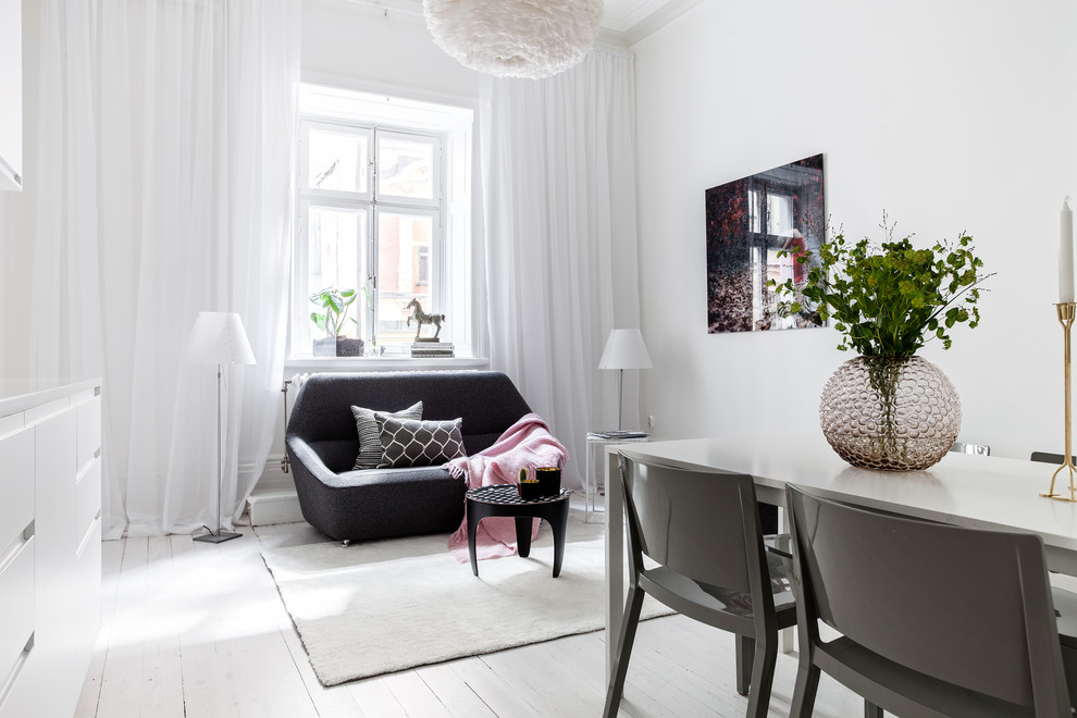 This is an example of a mid-sized scandinavian open concept living room in Stockholm with white walls and painted wood floors.