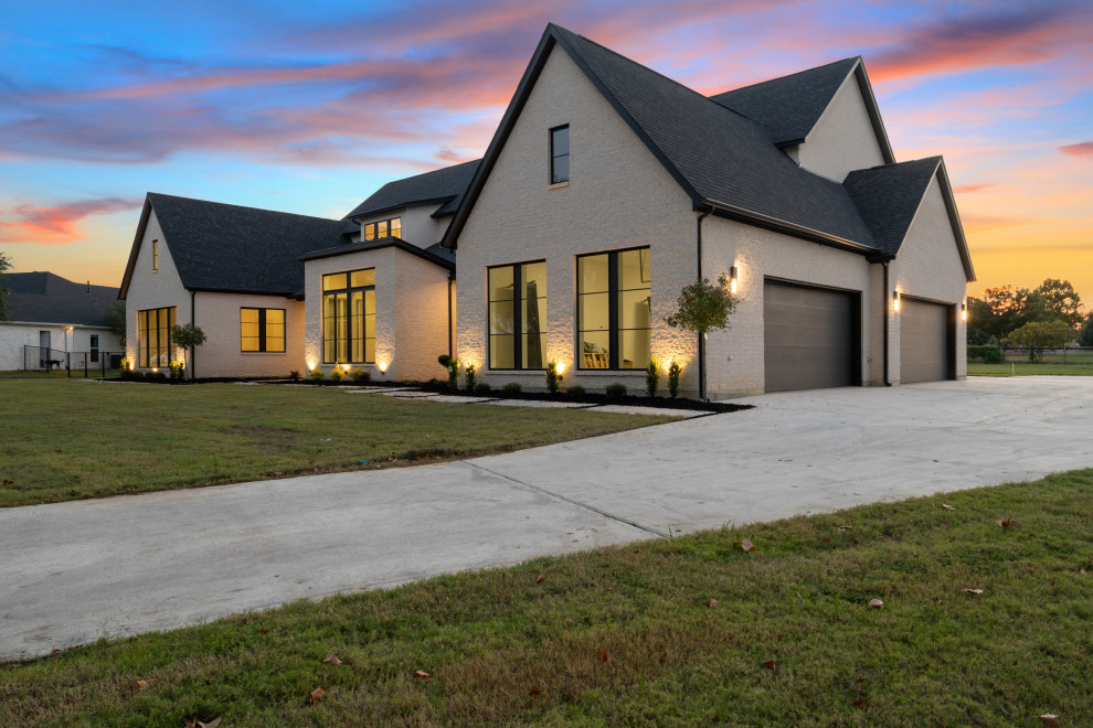 This is an example of a large modern two-storey white house exterior in Dallas with stone veneer, a gable roof, a shingle roof and a black roof.