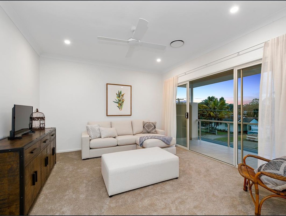 This is an example of a mid-sized contemporary open concept family room in Brisbane with white walls and carpet.