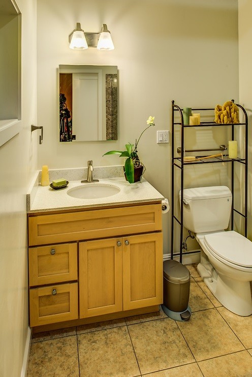 Photo of a small traditional 3/4 bathroom in San Francisco with recessed-panel cabinets, light wood cabinets, a two-piece toilet, beige walls, porcelain floors, an undermount sink, engineered quartz benchtops and beige floor.