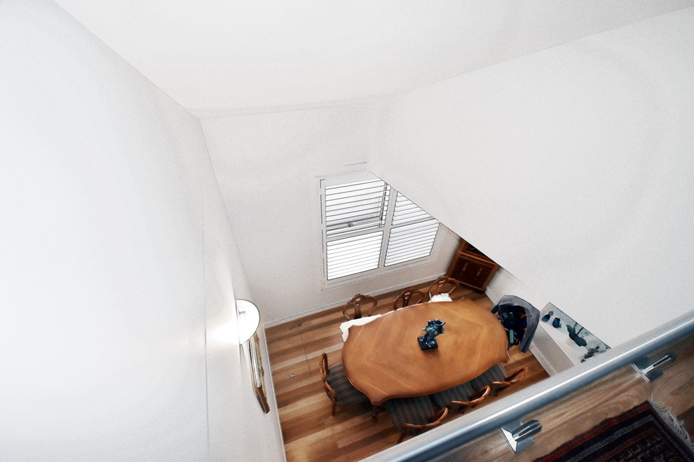 Inspiration for a mid-sized contemporary separate dining room in Sydney with white walls, medium hardwood floors and brown floor.