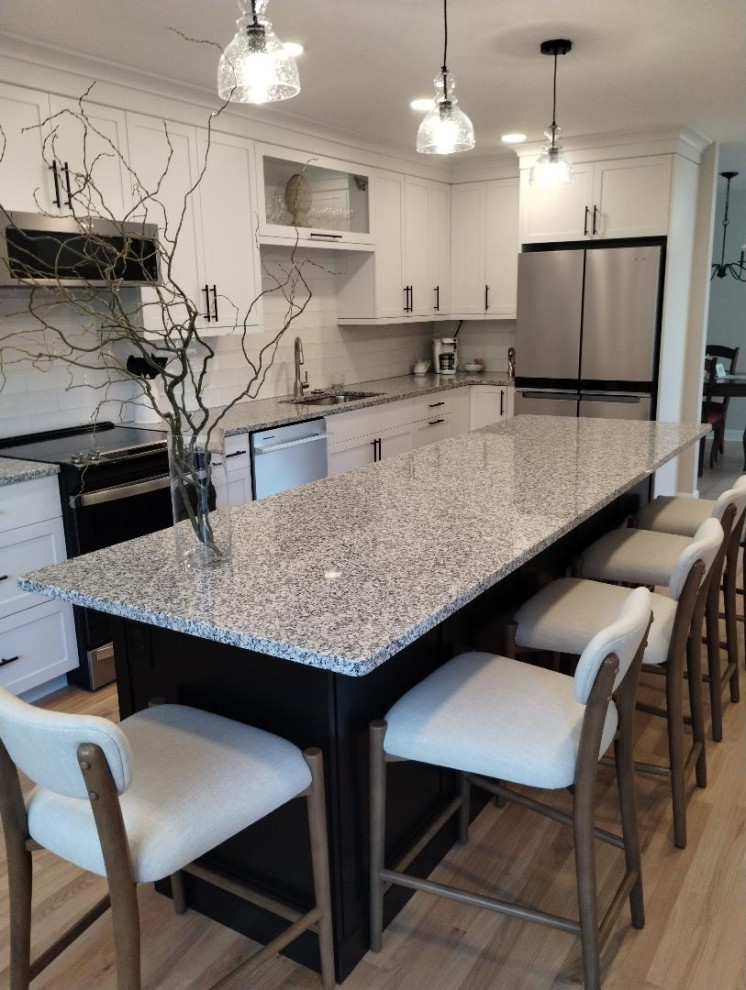 Transitional kitchen photo in Detroit with shaker cabinets, white cabinets, white backsplash and an island