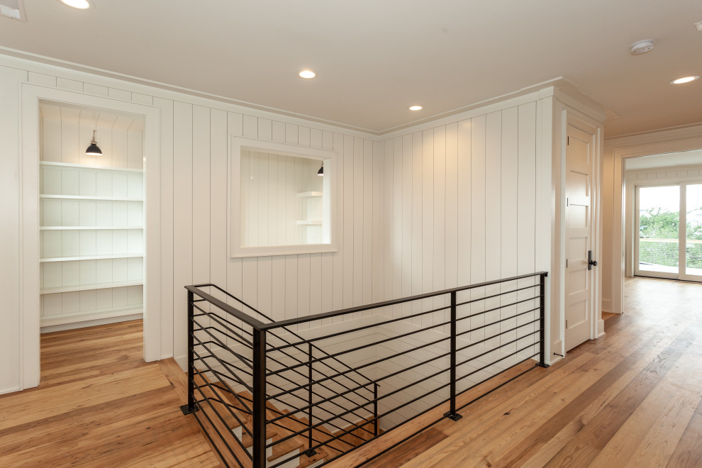 Design ideas for a large beach style wood u-shaped staircase in Charleston with painted wood risers, metal railing and planked wall panelling.